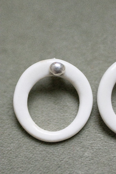 A silver moon and its porcelain orbit - two earrings in one