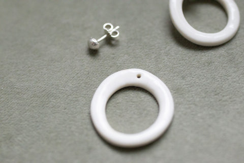 A silver moon and its porcelain orbit - two earrings in one