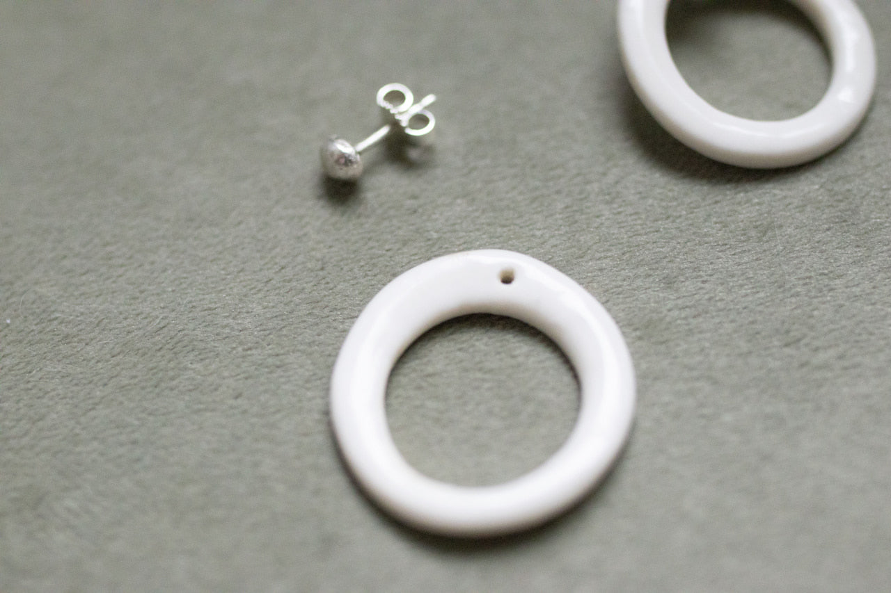 A silver moon and its porcelain orbit - two earrings in one